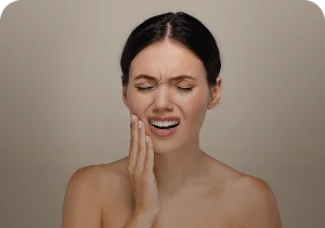 Woman holding her jaw in pain – bruxism