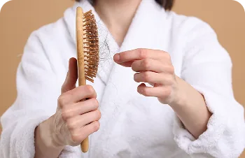 Diffuse hair loss – woman holding a hairbrush and shed hair
