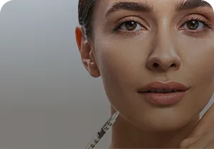 Woman with a syringe beside the jawline – fillers and facial contouring