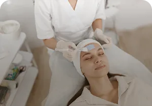 Aesthetician cleansing a client's face – medical facial cleansing